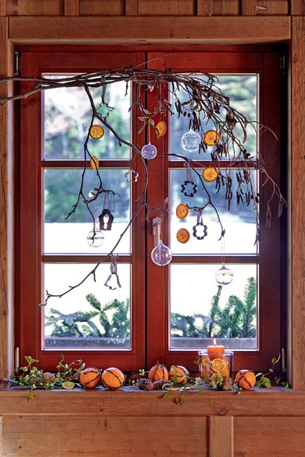 Idée de déco de Noël avec des branches de sapin et des oranges séchées