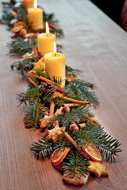 Idée de déco de Noël avec des branches de sapin et des oranges séchées